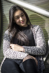 Chica joven morena posando con ropa de otoño invierno. Modelo posando con chaqueta de lana.