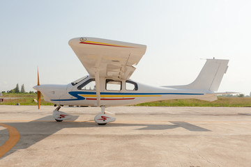 Small airplane with propeller in front parking on runway.