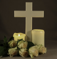 Kreuz, Kerzen und weiße Rosen