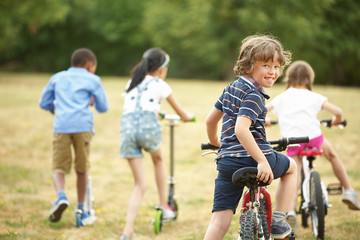 Kinder mit Mountainbikes und Tretroller
