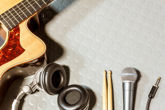 Top view the classic guitar,microphone,headphones, drum stick.