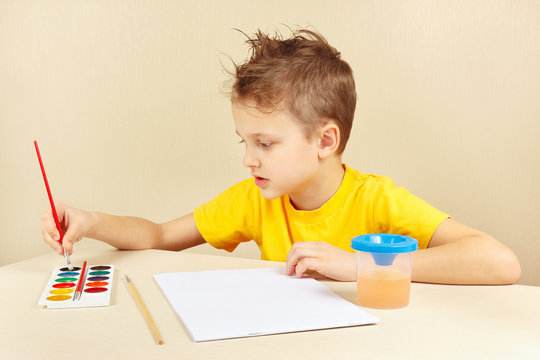 Young artist in a yellow shirt going to paint colors