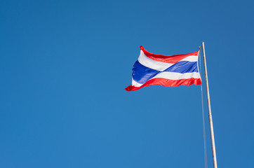 Flag of Thailand with clear blue sky.