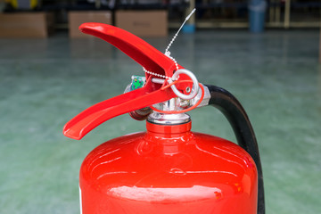 Hand pulling pin of fire extinguisher