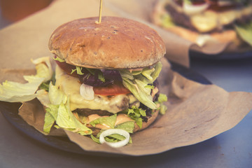 close on fast food unhealthy burger on paper, vintage effect