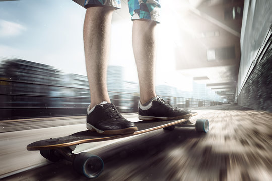 teenager rides longboard in the city