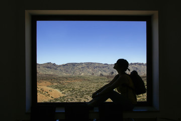 woman framed by a window and the Teide rocky mountains