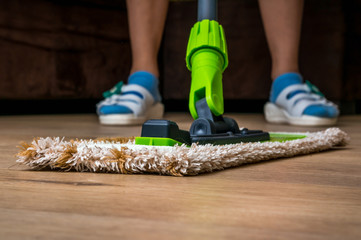 Woman with mop mopping wooden laminate floor