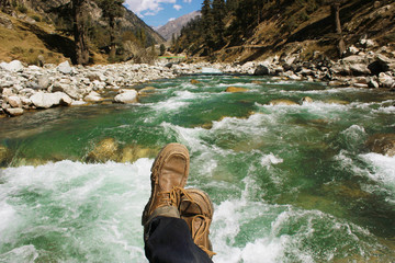 POV shot of a traveller on the bridge of a river