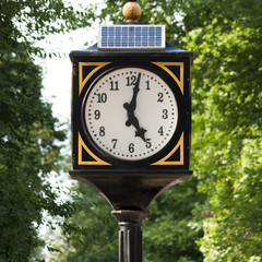 Fototapeta na wymiar The town clock on solar energy in the park