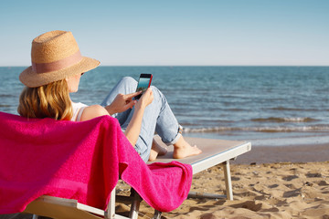 Woman with handy on the seaside