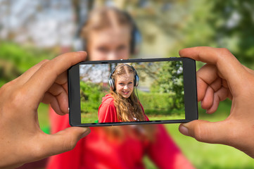 Taking photo of lady listening to music with mobile phone