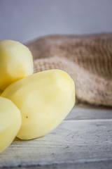 peeled potatoes on white wooden table