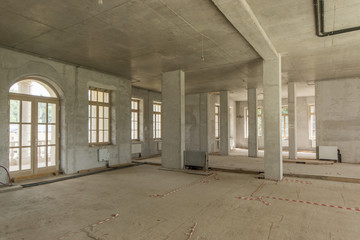 Room with concrete walls and balcony in building under construction without finishing