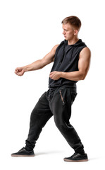 Naklejka premium Side view of handsome muscled young man pulling something isolated on white background