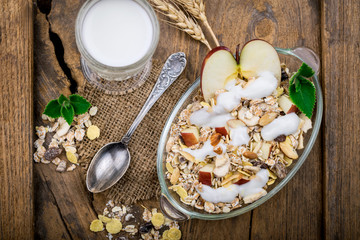Healthy bowl of muesli, apple, fruit, nuts and milk for a nutrit