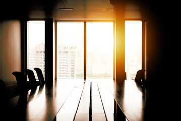 Fototapeta premium Empty meeting conference room with cityscape view in background in evening