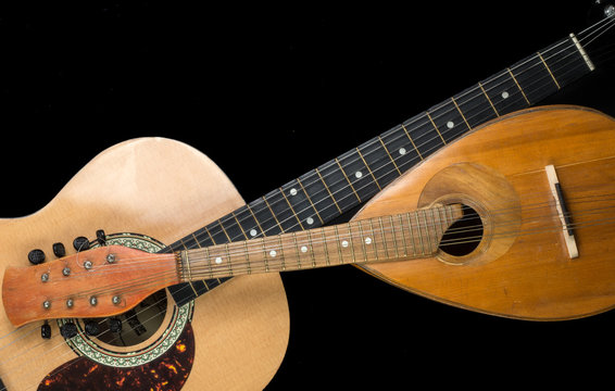 Mandolin and guitar on a black background. Stringed Musical Instruments.