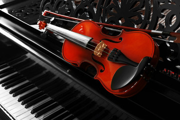 Violin lying on piano, close up