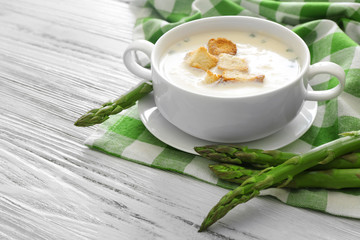 Asparagus soup with crackers on table