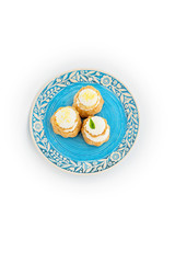 Desserts on plate top view. Eclairs with cream on blue plate.  - 118757894