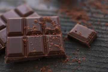 Pile of milk chocolate bars on old wooden background