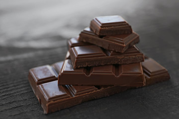 Pile of milk chocolate bars on old wooden background