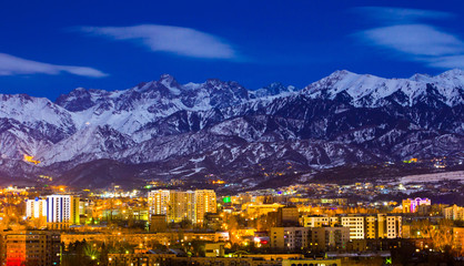 Almaty and mountains under the moonlight
