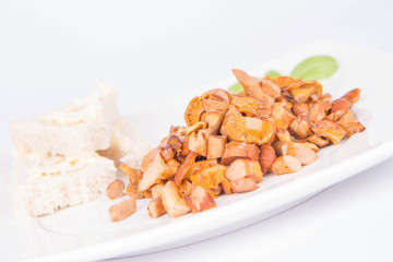 Sauteed chanterelle with garlic and some white bread on a plate decorated with basil