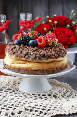 Cheesecake with chocolate topping decorated with summer fruits