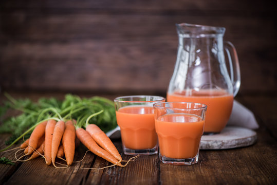 fresh carrot juice in jar and glasses