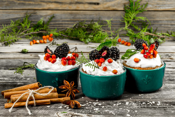 beautiful Christmas cupcake with cream and berry on wooden background cinnamon cones