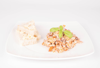 Sauteed chanterelle with cream and garlic and some white bread on a plate decorated with basil