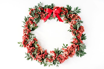 Fototapeta na wymiar red rowan wreath frame with bow on white background. flat lay, frame wreath, autumn wallpaper