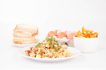 Scrambled eggs with chanterelle and parsley on a white background