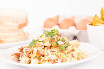 Scrambled eggs with chanterelle and parsley on a white background