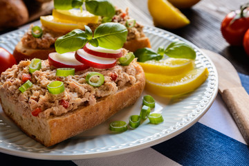 Slices of baguette with tuna spread, red pepper and green onion