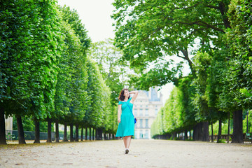 Fototapeta na wymiar Beautiful young woman walking in Parisian Tuileries park