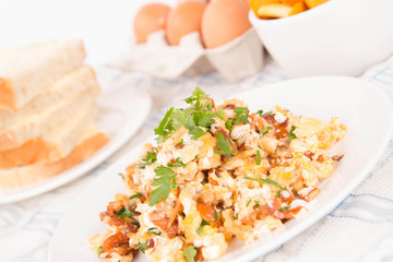 Scrambled eggs with chanterelle and parsley on a white background