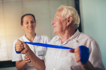 Senior man doing exercises using a strap to extend 