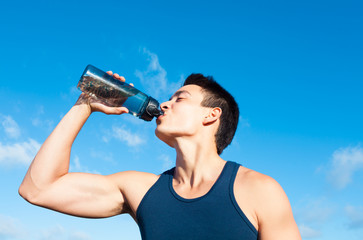 Fit man drinking bottle of water. 