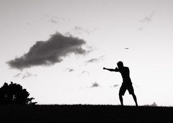 Male fighter practicing boxing outdoors. 