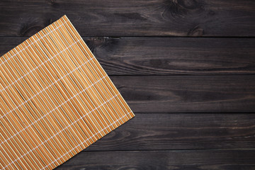 Bamboo mat on wooden table, top view
