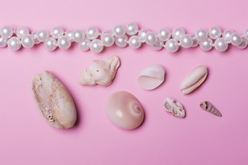 Sea shells and pearls on a pink background
