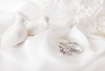 wedding rings on white silk background