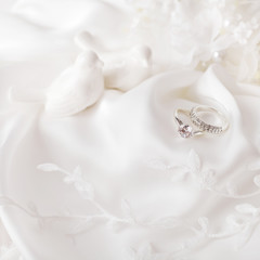 wedding rings on white silk background