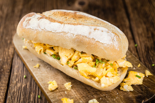Fresh baked Bun with Scrambled Eggs on wooden background