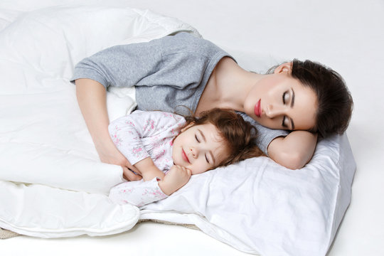 Beautiful mother and daughter in bed