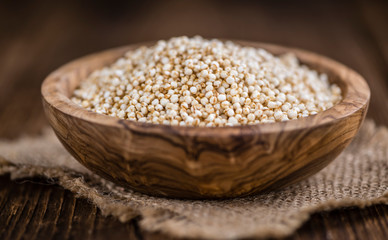 Puffed Quinoa (selective focus; close-up shot) on wooden backgro