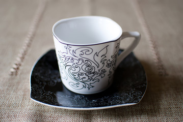 Empty white cup on a black saucer; vintage design